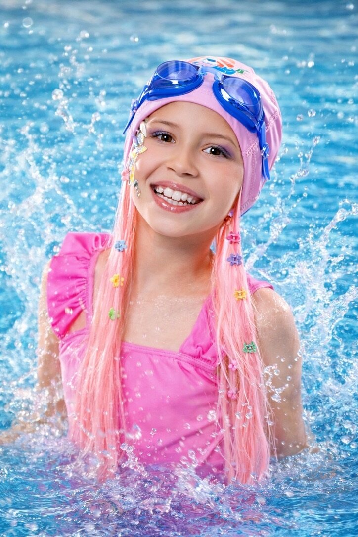 Girl at pool wearing SwimHair cap — flowers in hair