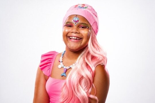 Brown-skinned girl with SwimHair cap and gems — zero detangling